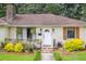 Close up of a front entrance featuring a decorative stone and a well-maintained yard with vibrant flowers at 22 Charlestowne Rd, Charleston, SC 29407