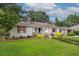 Charming single-story home with a well-manicured lawn and landscaped garden beds under a cloudy sky at 22 Charlestowne Rd, Charleston, SC 29407