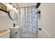 Cozy bathroom features a vanity, round mirror, and shower with blue and white patterned curtain at 2317 Kent Ave, North Charleston, SC 29405