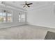Spacious carpeted bedroom with tray ceiling, ceiling fan, and windows providing natural light and neighborhood views at 2516 Willbrook Ln, Mount Pleasant, SC 29466