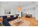 Open-concept living space with blue sofa, kitchen island with stools, and modern lighting at 2516 Willbrook Ln, Mount Pleasant, SC 29466