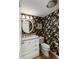 Charming bathroom featuring floral wallpaper, round mirror and a vanity at 2653 Seabrook Island Rd, Seabrook Island, SC 29455
