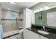 Well-lit bathroom with a modern glass shower, neutral tile, and stylish black countertop at 2653 Seabrook Island Rd, Seabrook Island, SC 29455