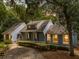Inviting home exterior featuring blue siding, warm interior lights, manicured hedges, and a welcoming entrance at 2653 Seabrook Island Rd, Seabrook Island, SC 29455