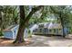 Inviting blue home features a well-maintained lawn, mature trees, and an attached garage with a paved driveway at 2653 Seabrook Island Rd, Seabrook Island, SC 29455