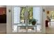 Bright interior view features a plant display in front of a large window looking out onto a wooded landscape at 2653 Seabrook Island Rd, Seabrook Island, SC 29455