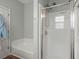 Bright bathroom featuring a walk-in shower with glass door and white tiled walls at 2845 August Rd, Johns Island, SC 29455