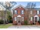 Brick townhome with black shutters, a manicured lawn, and beautiful shade trees at 301 Broad St # 1, Charleston, SC 29401