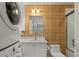 Bathroom featuring white vanity, gold accent wall, stacked washer and dryer unit and tub with glass door at 321 Lapwing Ln, Mount Pleasant, SC 29464