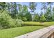 Serene backyard view featuring a pond, lush green grass, mature trees, and a wooden fence at 348 Spindlewood Way, Charleston, SC 29414