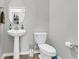 This half bathroom features a pedestal sink, an oval mirror, and updated fixtures at 348 Spindlewood Way, Charleston, SC 29414