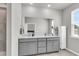 Bathroom with double sink vanity, large mirror, linen cabinet and natural light at 348 Spindlewood Way, Charleston, SC 29414