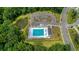 Aerial view of a well-maintained community pool area with a pool house, parking, and a scenic pond at 348 Spindlewood Way, Charleston, SC 29414