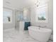 Elegant bathroom showcasing a glass shower, free-standing tub, plantation shutters, and marble floors at 3739 Goodwater St, Mount Pleasant, SC 29466