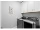 Modern laundry room featuring a gray washer and dryer with white cabinets above at 3739 Goodwater St, Mount Pleasant, SC 29466