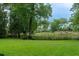 Expansive backyard with lush lawn, mature trees, and scenic view of the water and dock at 375 Seewee Cir, Mount Pleasant, SC 29464