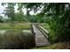 Picturesque view of a wooden dock extending into a tranquil marsh, surrounded by lush greenery and peaceful scenery at 375 Seewee Cir, Mount Pleasant, SC 29464