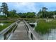 Picturesque view of a private dock with a boat, extending into the calm, grassy waterway at 375 Seewee Cir, Mount Pleasant, SC 29464