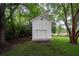 Detached garage with white siding and a charming round window, nestled among lush green trees at 375 Seewee Cir, Mount Pleasant, SC 29464