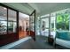 Inviting sunroom with gray painted floors, screen doors, and comfortable wicker furniture at 375 Seewee Cir, Mount Pleasant, SC 29464