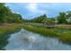 Scenic waterfront view featuring a wooden dock and tranquil waters surrounded by lush vegetation and natural beauty at 375 Seewee Cir, Mount Pleasant, SC 29464