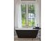 Black tub with a gold faucet sits under a window overlooking a lawn at 3871 Sawyers Island Dr, Mount Pleasant, SC 29466