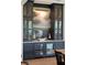 Custom built-in bar with wine cooler, striking artwork, and brass hardware in a dining room at 3871 Sawyers Island Dr, Mount Pleasant, SC 29466