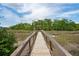 Scenic view of a wooden dock leading to a gazebo and marshland, perfect for nature enthusiasts at 3871 Sawyers Island Dr, Mount Pleasant, SC 29466