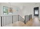 Bright hallway with black iron banister, wood floors, white walls, black framed windows, and statement light fixture at 3871 Sawyers Island Dr, Mount Pleasant, SC 29466