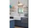 Close-up of a modern kitchen with navy blue cabinets, white countertops, and stainless steel appliances at 3871 Sawyers Island Dr, Mount Pleasant, SC 29466