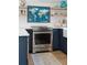 Bright kitchen with stainless steel oven and elegant navy blue cabinetry and wooden shelving at 3871 Sawyers Island Dr, Mount Pleasant, SC 29466