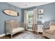 Bedroom room featuring a crib, rocking chair, and a calming blue color scheme at 3873 Hanoverian Dr, Mount Pleasant, SC 29429