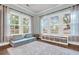 A sunlit room with a large rug, plush seating, and built in storage beneath large windows at 3873 Hanoverian Dr, Mount Pleasant, SC 29429