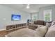 Living room with a large sectional couch, wall-mounted TV, and storage shelving at 3873 Hanoverian Dr, Mount Pleasant, SC 29429