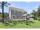 Spacious backyard with lush green grass, a screened porch, and mature trees at 404 Bowstring Dr, Huger, SC 29450