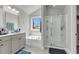 Bright bathroom with a soaking tub, tiled shower, and window view to the trees outside at 404 Bowstring Dr, Huger, SC 29450