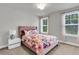 Inviting bedroom features a plush bed, soft pink accents, and natural light from two windows at 404 Bowstring Dr, Huger, SC 29450