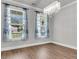 Elegant dining room featuring hardwood floors, large windows with blue curtains, and a stunning chandelier at 404 Bowstring Dr, Huger, SC 29450