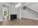 Open-concept space with hardwood floors, chandelier, and staircase, seamlessly connecting the dining area to the rest of the home at 404 Bowstring Dr, Huger, SC 29450