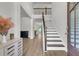 Welcoming foyer with hardwood floors, staircase, and natural light flowing throughout the open concept living space at 404 Bowstring Dr, Huger, SC 29450