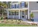 Charming two-story home with a welcoming front porch, blossoming garden, and a meticulously maintained yard at 404 Bowstring Dr, Huger, SC 29450