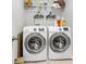 Convenient laundry room equipped with modern washer and dryer units and storage shelving at 404 Bowstring Dr, Huger, SC 29450