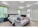 Bright main bedroom with a tray ceiling, a sitting bench, and a view to the bathroom at 404 Bowstring Dr, Huger, SC 29450