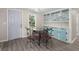 Cozy dining area featuring a glass-topped table, four chairs, and built-in cabinets with glass doors at 407 Raysor St, Saint George, SC 29477