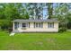 Charming single-story home with light yellow siding, gray shutters, and a well-maintained green lawn at 407 Raysor St, Saint George, SC 29477