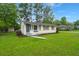A cozy, single-level home with a vibrant green lawn, offering great curb appeal in a quiet neighborhood at 407 Raysor St, Saint George, SC 29477