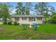 Charming home with a front yard featuring a cozy fire pit and lush green grass at 407 Raysor St, Saint George, SC 29477