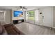 Inviting living room with wood-look floors, a ceiling fan, and a modern entertainment center with a fireplace at 407 Raysor St, Saint George, SC 29477