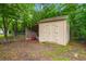 A storage shed in the back yard with double doors, and various items stored on the open side at 407 Raysor St, Saint George, SC 29477