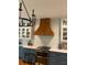 A kitchen features custom cabinets, tile backsplash and a wood vent hood at 4150 Nature View Cir, Johns Island, SC 29455